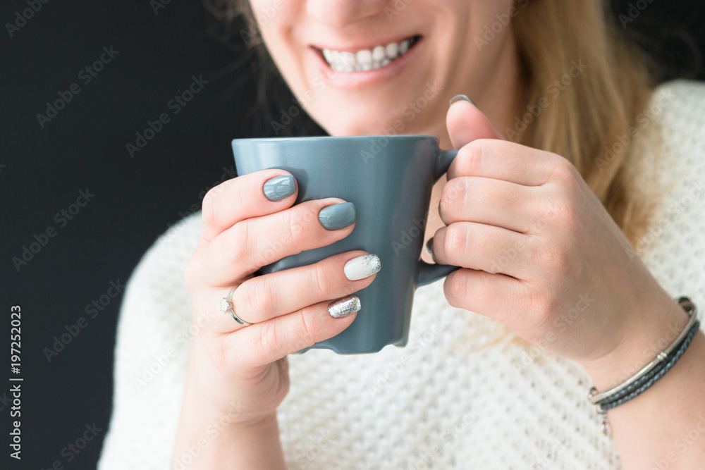 A woman with a beautiful fashionable manicure holds a cup of coffee or tea in her hands. Rest, relaxation. Free time. A woman with a beautiful fashionable manicure holds a cup of coffee or tea in her hands. Rest, relaxation. Free time.