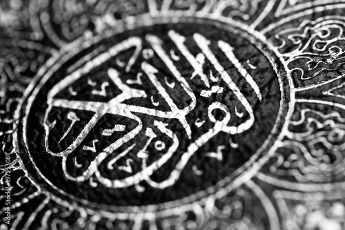 Black and white image of Islamic Book Quran with arabic calligraphy that means Al-Quran, the Holy Quran