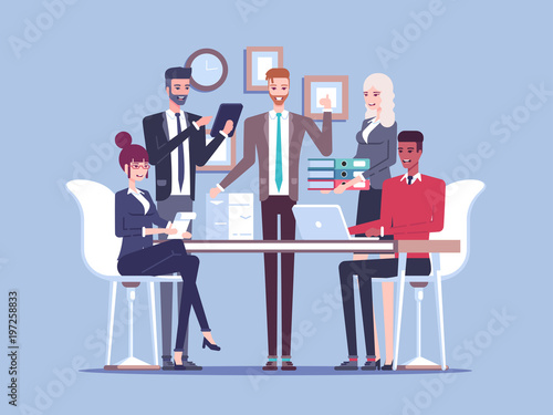 Team business people working together in the office, sitting and standing at the table, working with documents and talking to each other. Busy office work. Business concept teamwork and communication