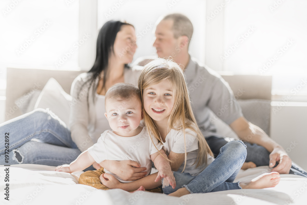 happy family on white bed in the bedroom