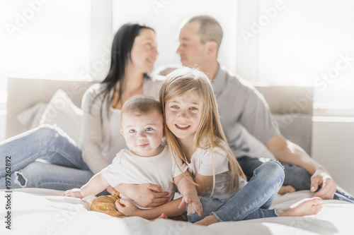 happy family on white bed in the bedroom