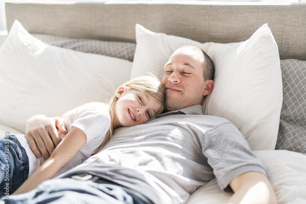 Father and daughter enjoying time in white bed Father and daughter enjoying time in white bed