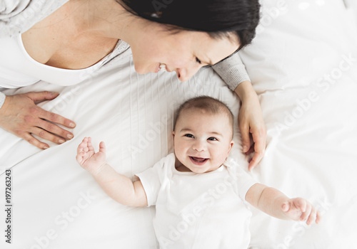 Mother with a baby on bed at home