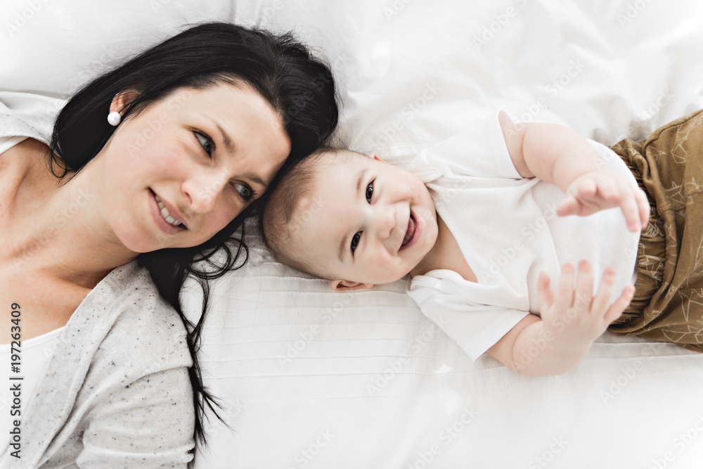 Mother with a baby on bed at home Mother with a baby on bed at home