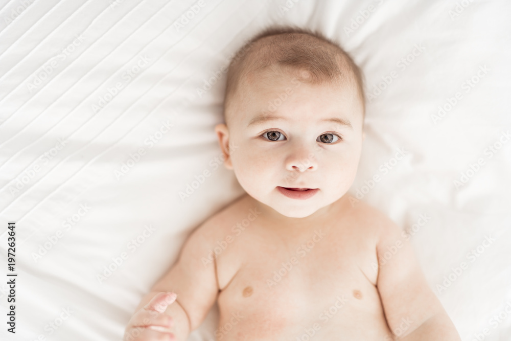Portrait of a baby boy on the bed in bedroom Portrait of a baby boy on the bed in bedroom