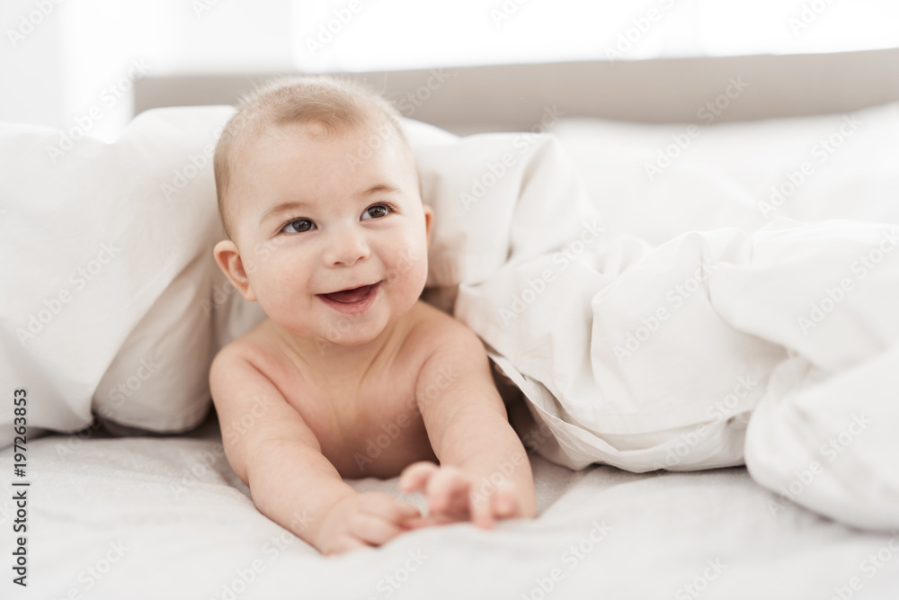 Portrait of a baby boy on the bed in bedroom