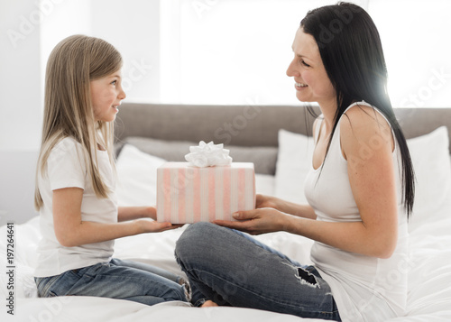 Happy mother's day! Child daughter congratulates moms and gives her a gift