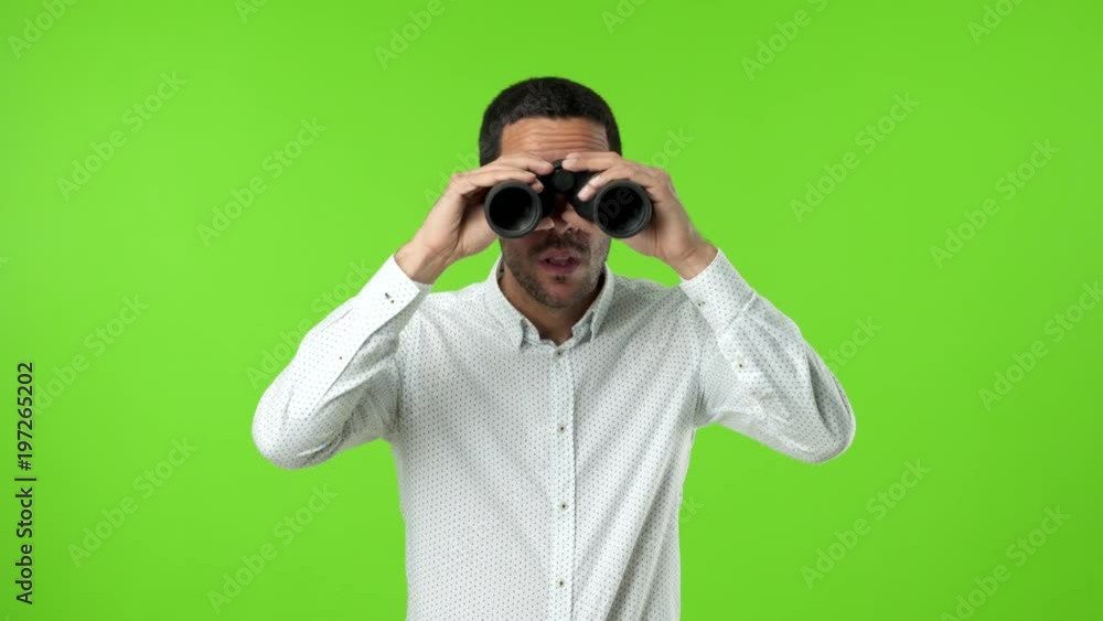Concentrated young man using a binoculars Concentrated young man using a binoculars
