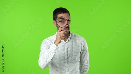 Concentrated young man using a magnifying glass