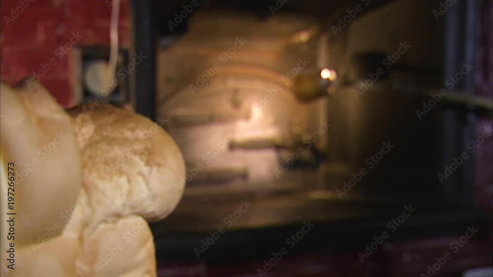 Focus shift from an old iron oven in the background to freshly baked bread in the foreground.