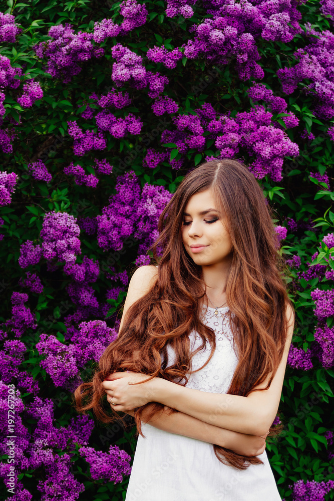Happy beautiful young woman with long hair in a blooming spring Park, the charming girl in a white dress with bright flowering trees, the girl on the background of flowering gardens Happy beautiful young woman with long hair in a blooming spring Park, the charming girl in a white dress with bright flowering trees, the girl on the background of flowering gardens