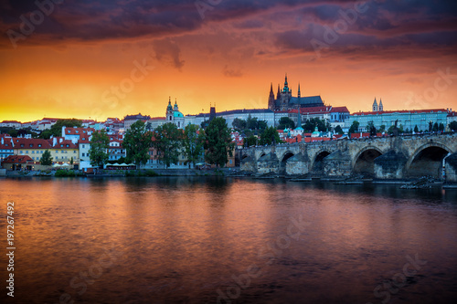Skyline of Charles bridge and Prague castle on Vltava river during afternoon. Storm clouds with red color. Old Town  Prague  Europe.