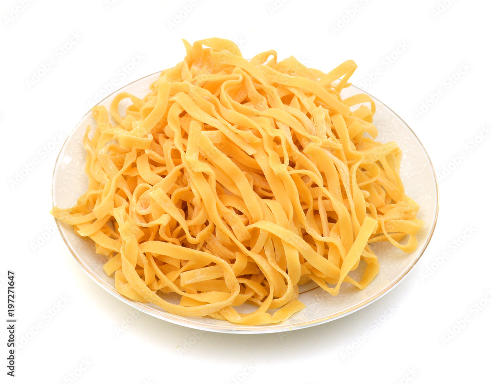 A portion of tagliatelle pasta in plate  isolated on white