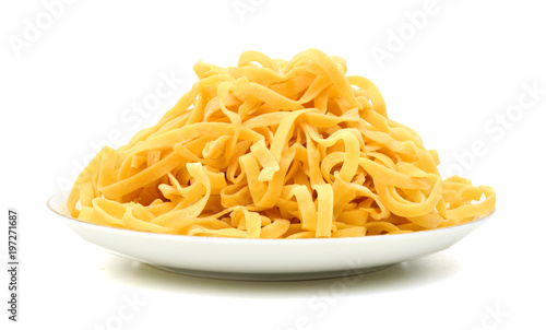 A portion of tagliatelle pasta in plate isolated on white
