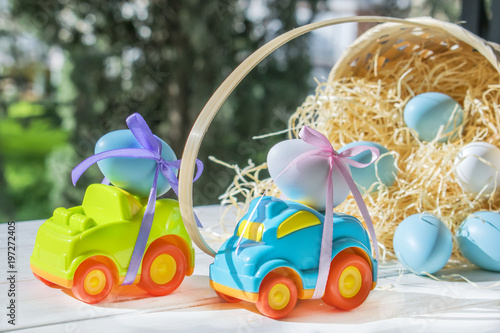 Car Easter egg on the background of baskets with hay and colored eggs