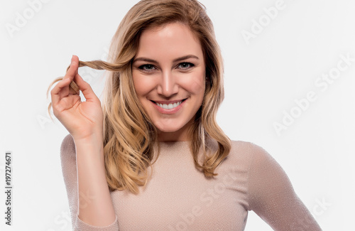 Attractive cute blonde. Close-up portrait on a white. Beautiful young woman in a flesh-colored dress.