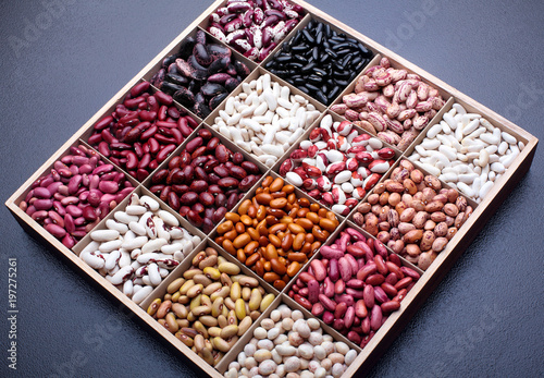 Different types of legumes beans. In wooden box.Varieties of beans.Small red bean,Scarlett runner bean Phaseolus coccineus ,butter bean,kidney bean,pinto and other sorts of beans.Top view.