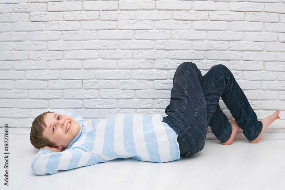 Cute boy lying on the floor of his room resting. Image with free space Cute boy lying on the floor of his room resting. Image with free space