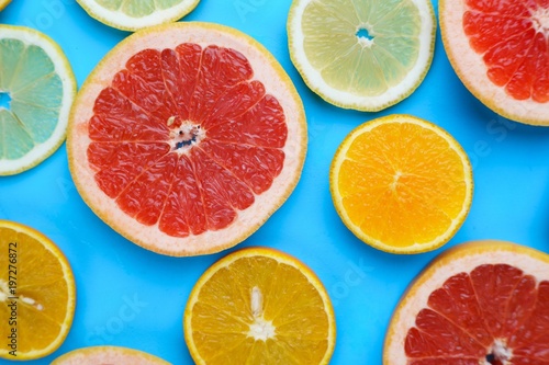 Citrus slices on blue background  flat lay. Bright vibrant summer background