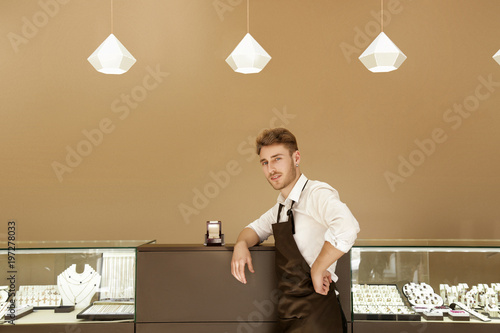 Konstfotografi male jeweler stands in a shop with jewelry