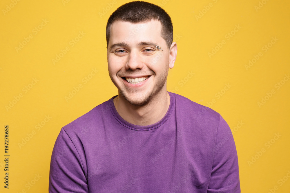 Portrait of young man with pierced eyebrow on color background Portrait of young man with pierced eyebrow on color background
