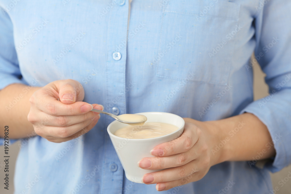 Woman holding bowl with vanilla pudding, closeup Woman holding bowl with vanilla pudding, closeup