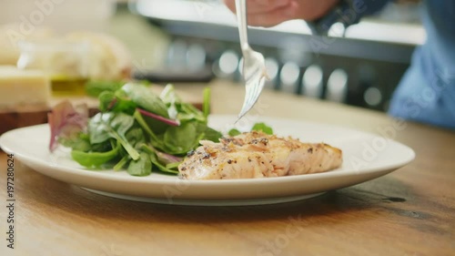 Man Having Grilled Fish Served With Salad At Home
