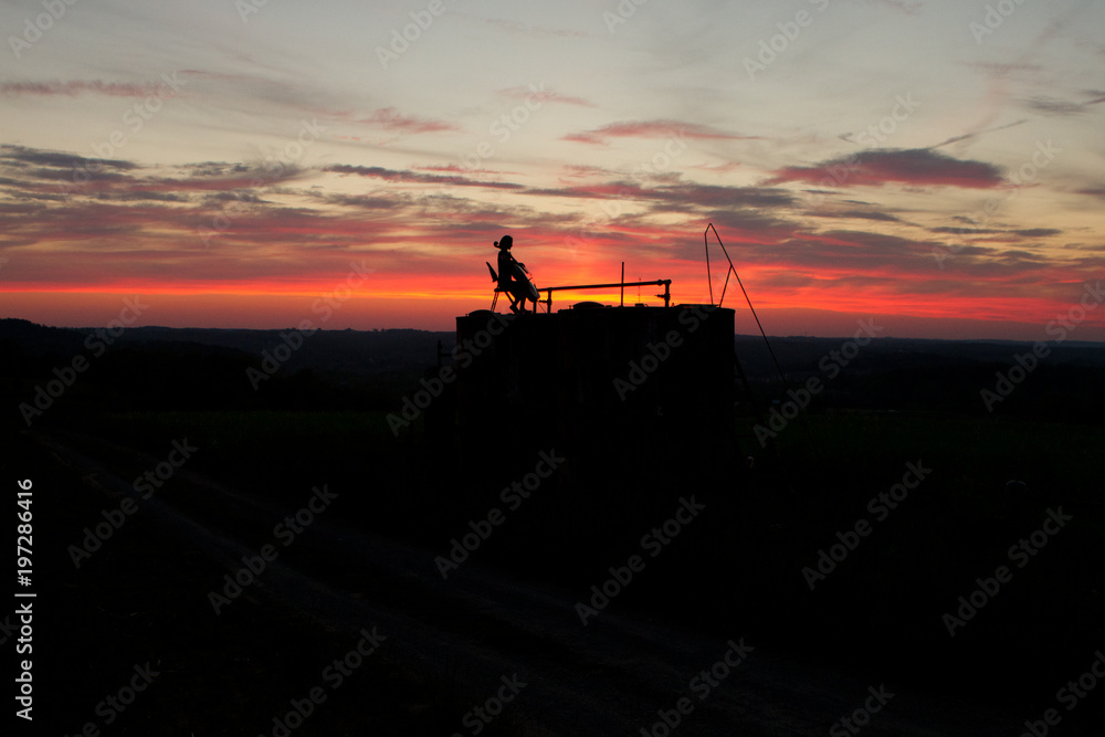 Naklejka premium woman playing cello music in a sunset 