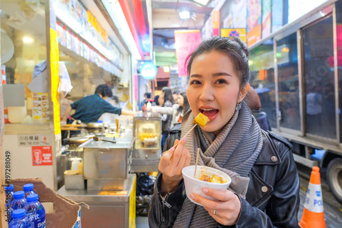 Photography Asian young woman eating Chinese steamed dumpling street food in Hong Kong