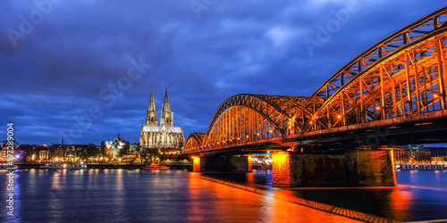 Cologne Cathedral and Hohenzollern Bridge, the most famous landmark of Cologne, Germany, at twilight time