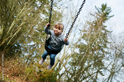 young girl on swing happy