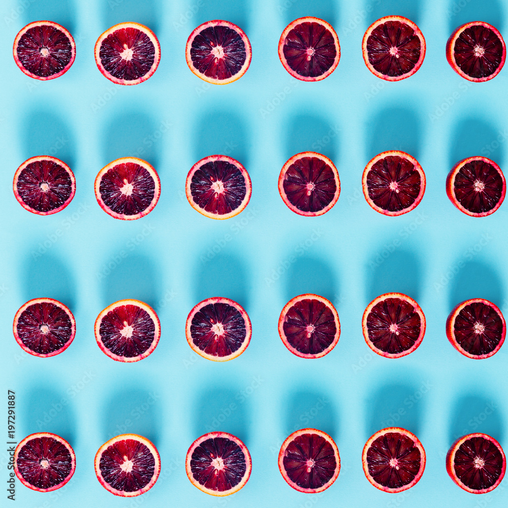 Fototapeta premium Red oranges on the bold blue background. Creative minimalism and modern food pattern concept