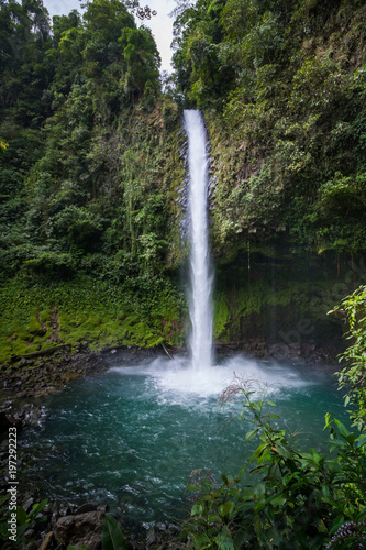 Waterfall into beautiful turquoise pool in Costa Rican rainforest