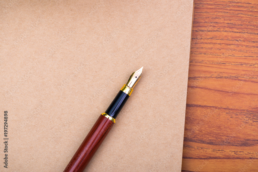 Fountain pen or ink pen with notebook paper on wooden working table with copy space, office desk concept. Fountain pen or ink pen with notebook paper on wooden working table with copy space, office desk concept.