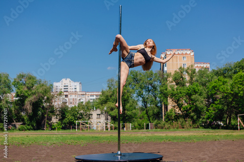 Fit attractive girl dancing near portable pole at summer day © Smile