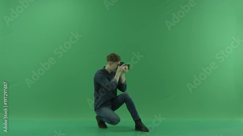 Sitting on the right hand side back photographer taking photos of a viewer on the green screen