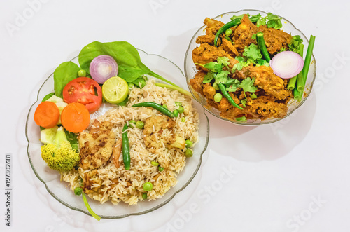 Indian cuisine meal dishes of veg fried rice and spicy chicken kosha with salad isolated on white background.