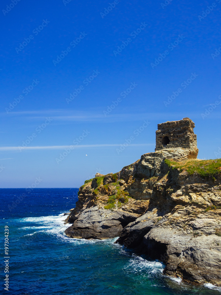 A ruined stone building on the edge of the port of Andros