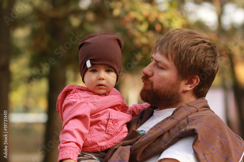 Father holding her little daughter in the park