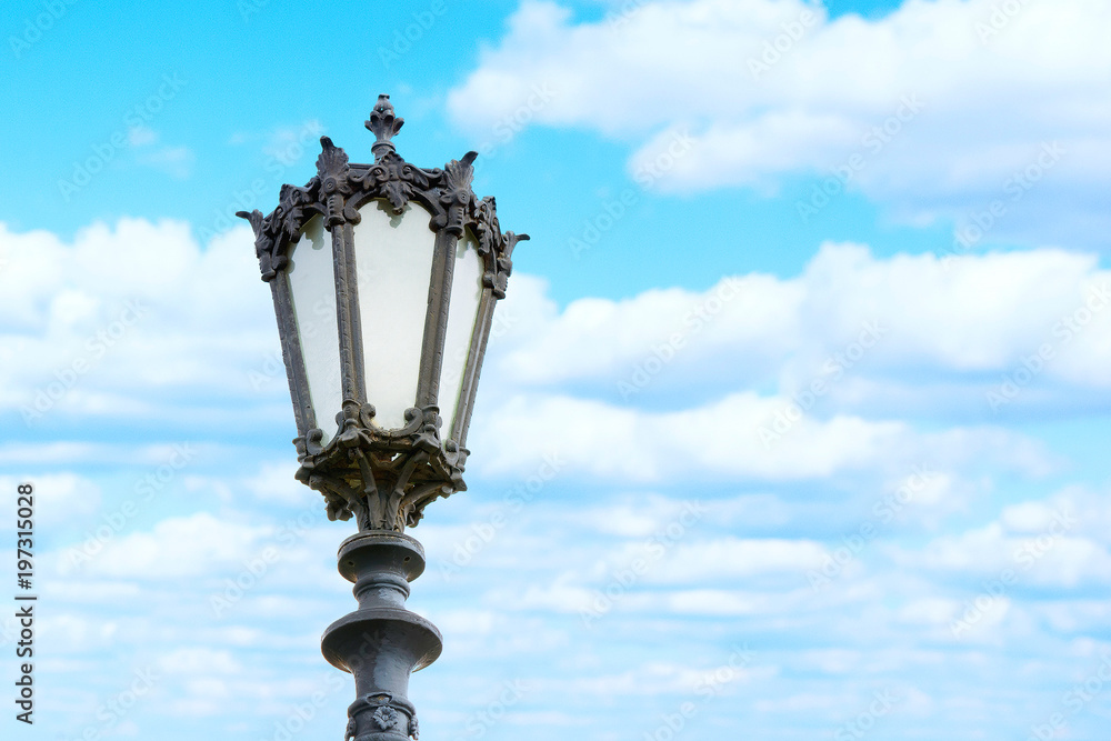Beautiful Old Street light on blue cloudly sky background. Space for text.