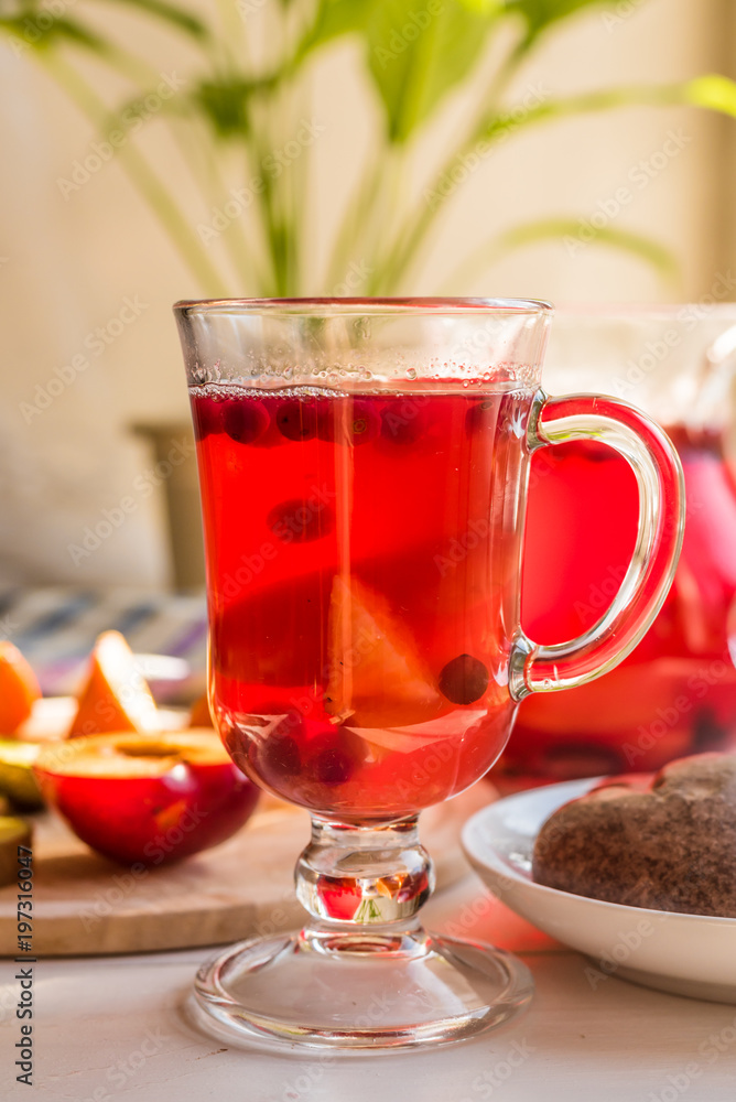 A glass with a cranberry drink on a rustic table, lit by the morning sun - the concept of a healthy life A glass with a cranberry drink on a rustic table, lit by the morning sun - the concept of a healthy life