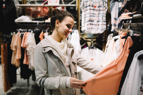 Young attractive woman buying clothes in mall