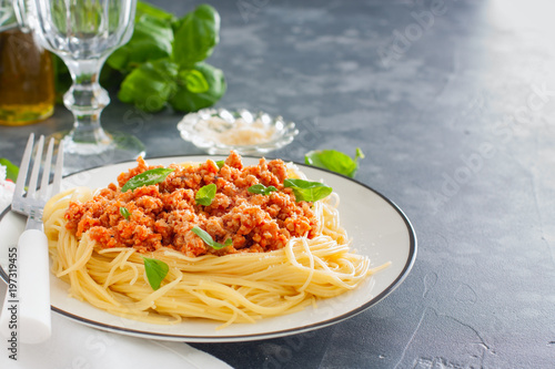 Spaghetti with meat ragout, tomato sauce, cheese on a white plate, horizontal, copy space
