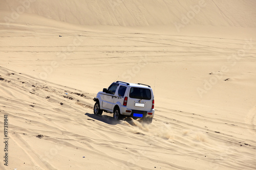 An suv was driving in the desert.