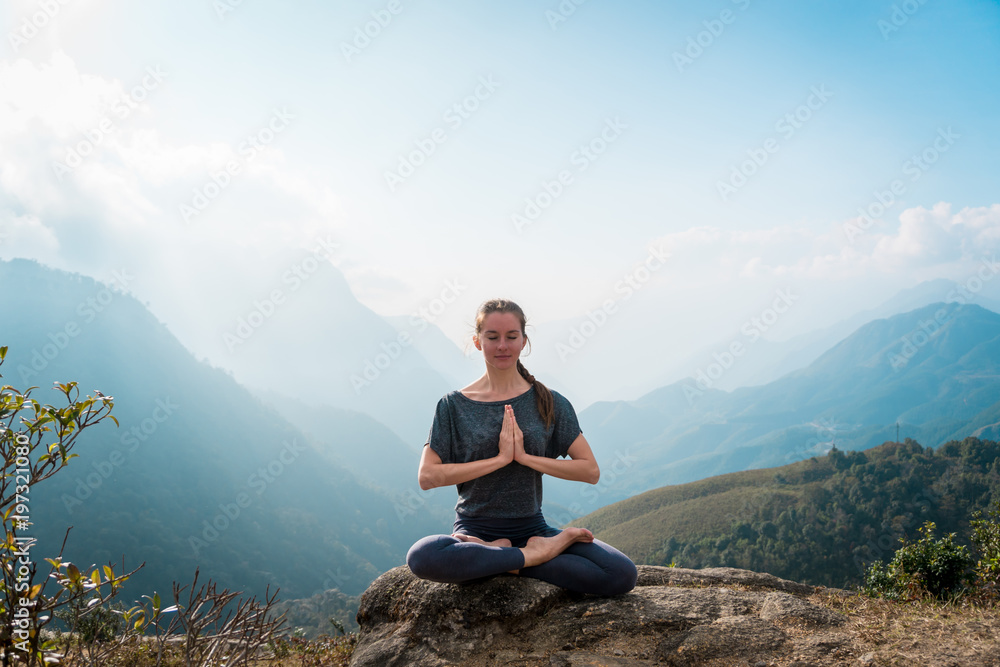 Meditating in lotus position, doing yoga exercises in morning