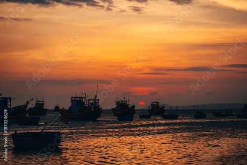 traditional Vietnamese fishing boats on the sea in the background of orange sunset