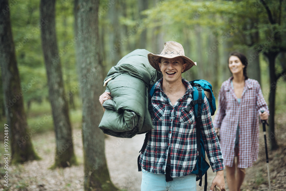 Young couple with happy faces walks. Man with woman hiking