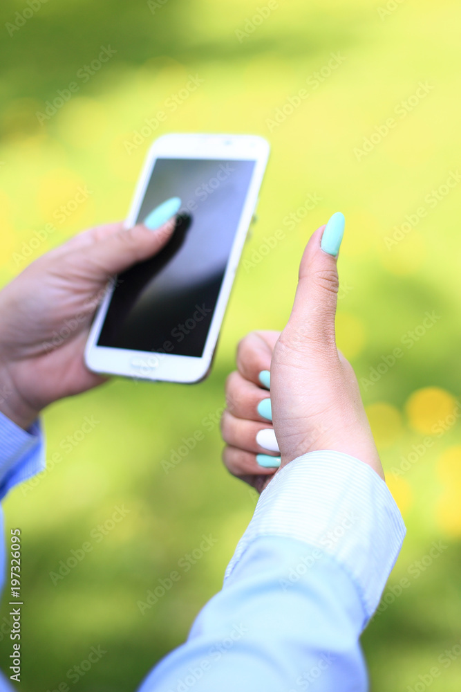 Woman using mobile smart phone in park.