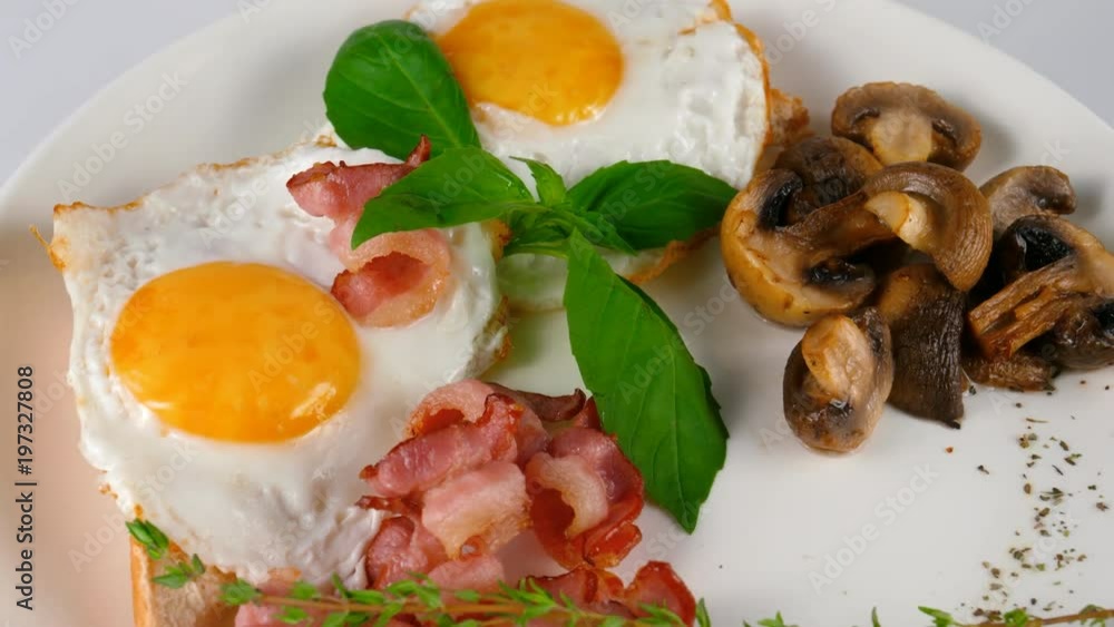 Fried eggs with bacon and sliced mushrooms, often dish on a breakfast, loop Fried eggs with bacon and sliced mushrooms, often dish on a breakfast, loop