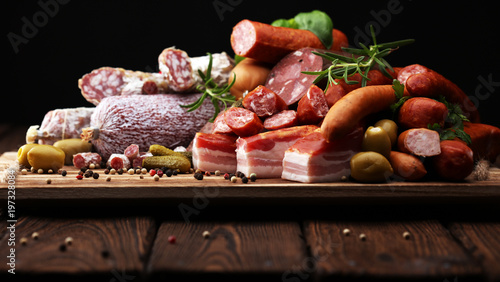 Food tray with delicious salami, ham, fresh sausages, cucumber and herbs. Meat platter